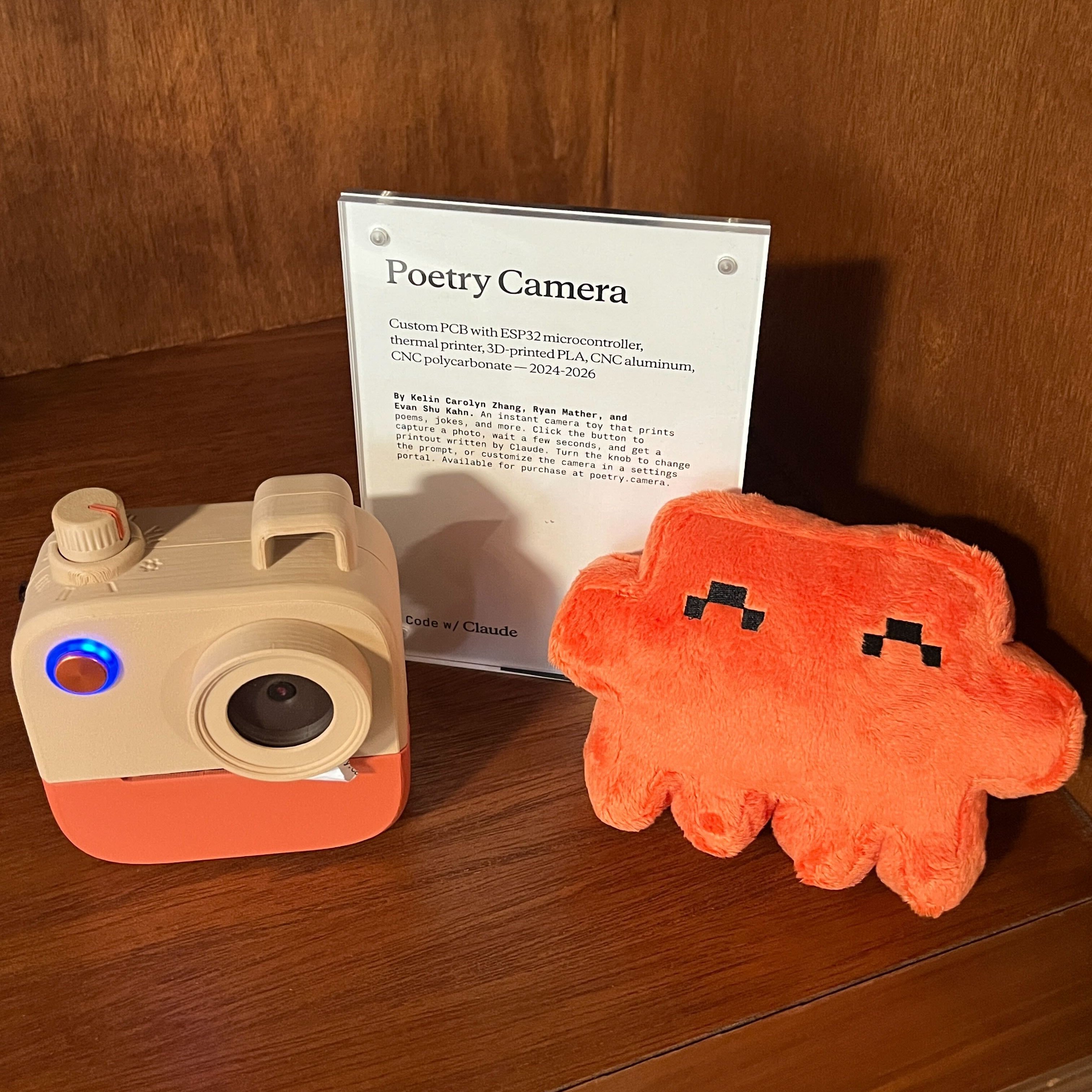 REPLACE: High quality photo of the Clawd plushie sitting on a desk or at the event.