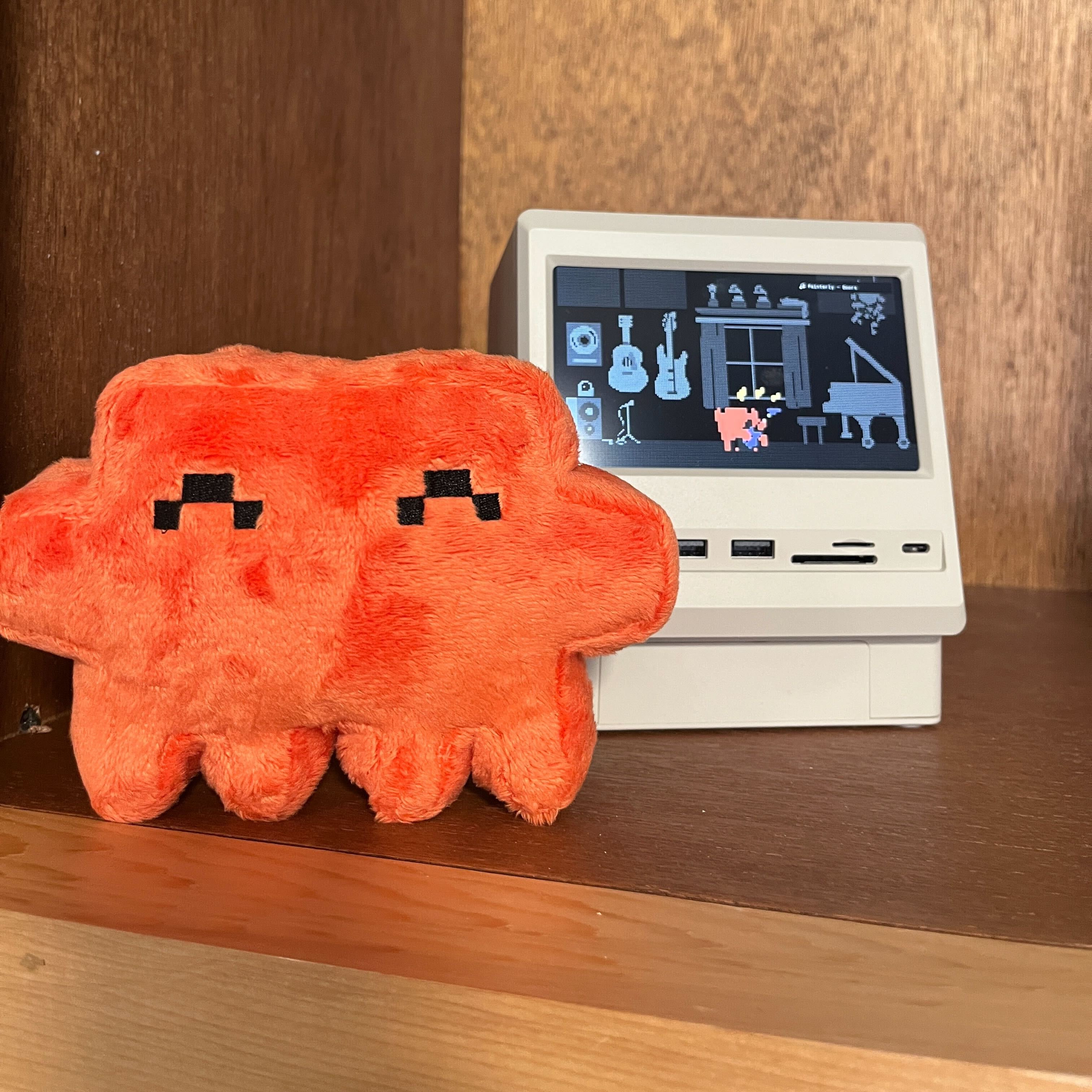 REPLACE: Close up shot focusing on the pixelated face of the Clawd plushie.